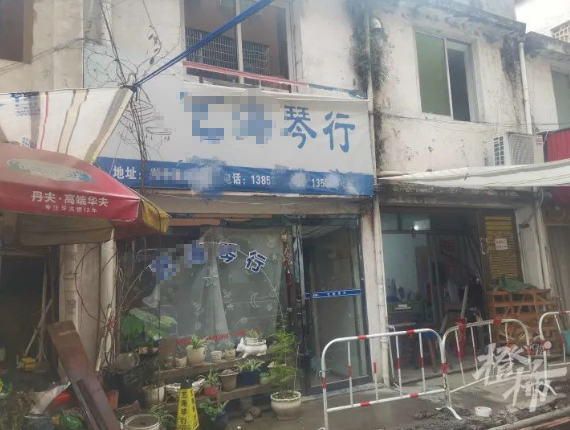 琴行招牌上留着的两个的电话已经无人接听